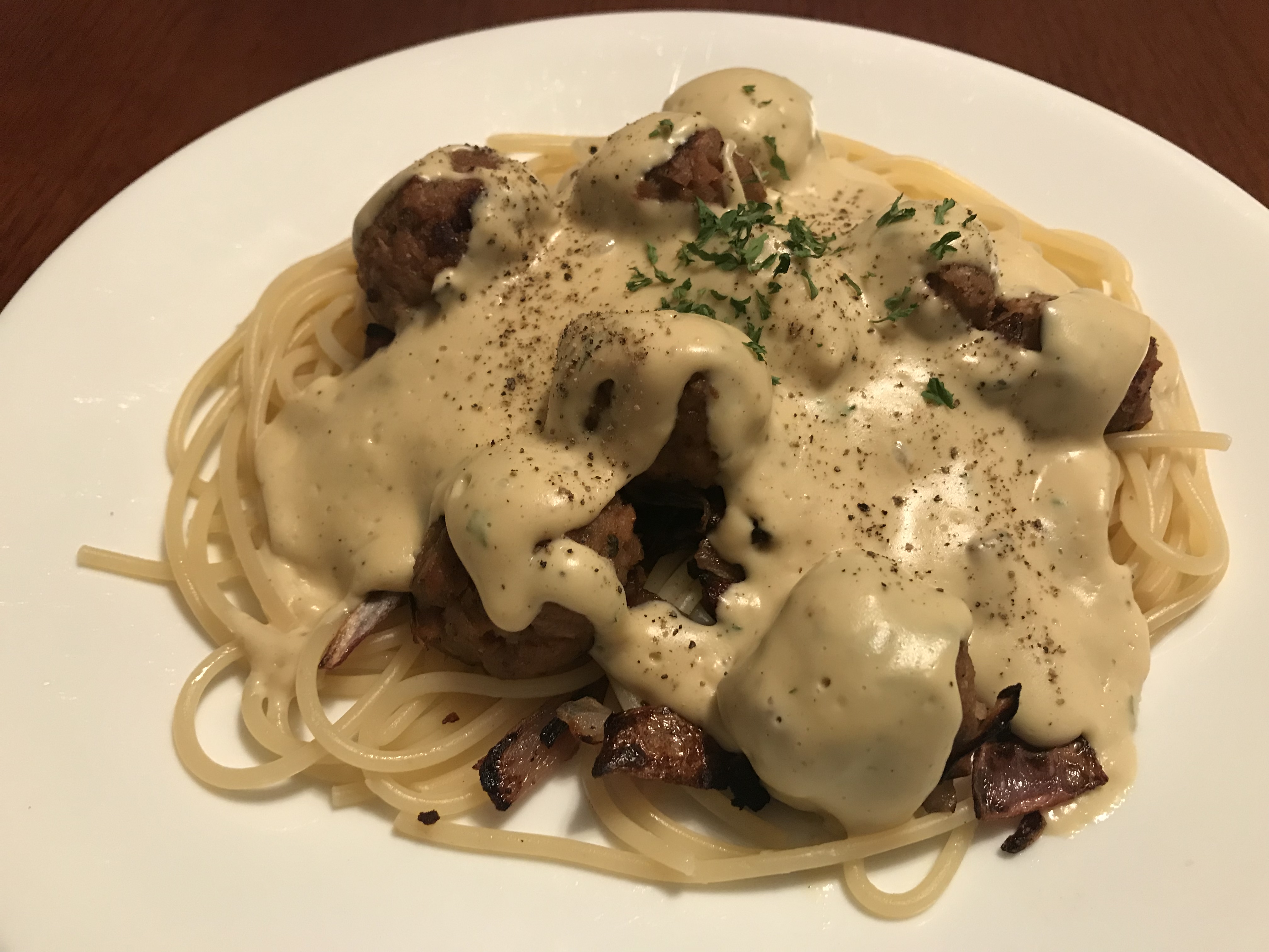 pasta and vegan meatballs topped with vegan alfredo sauce