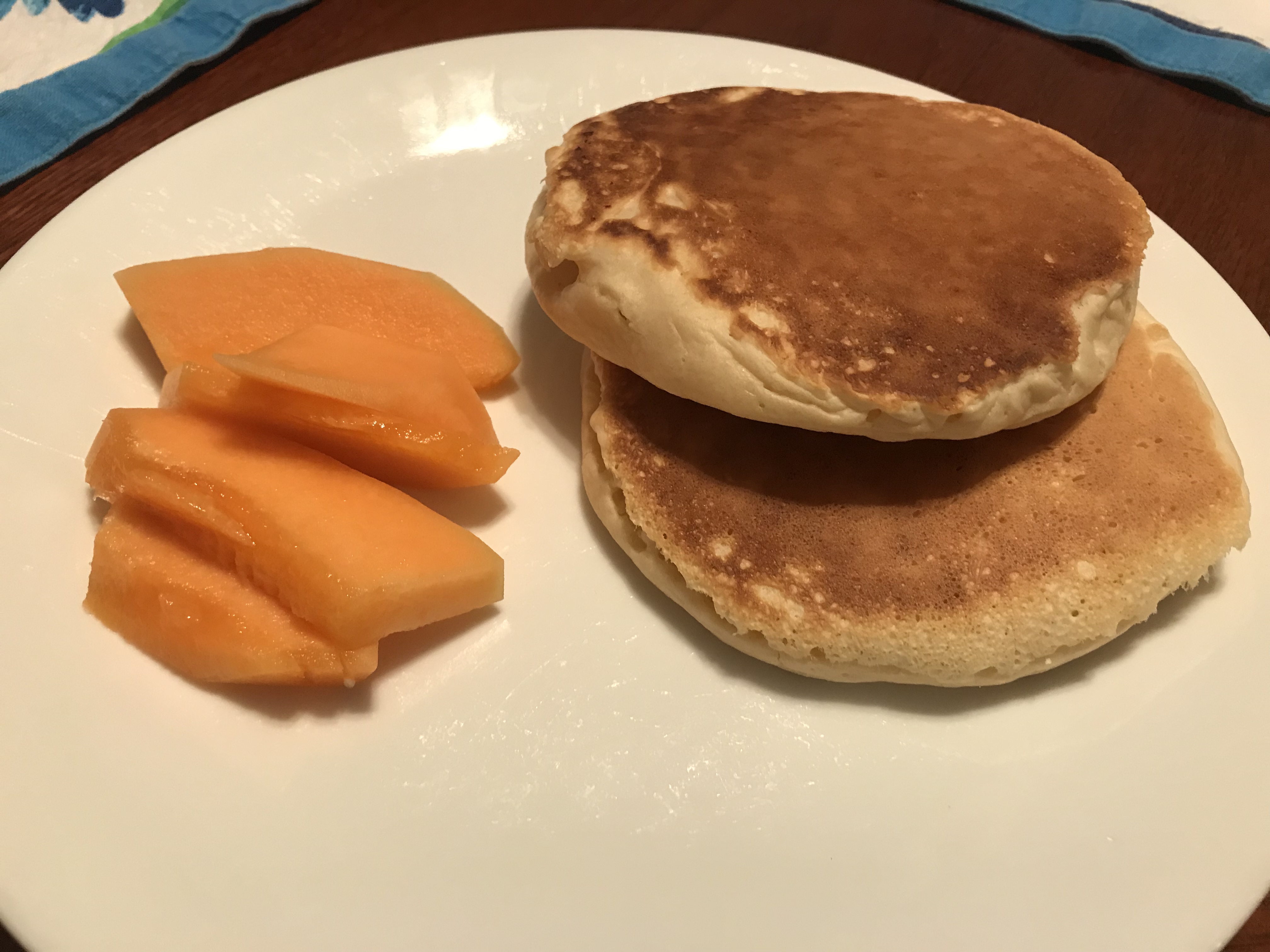 Two pancakes with cantaloupe on a plate