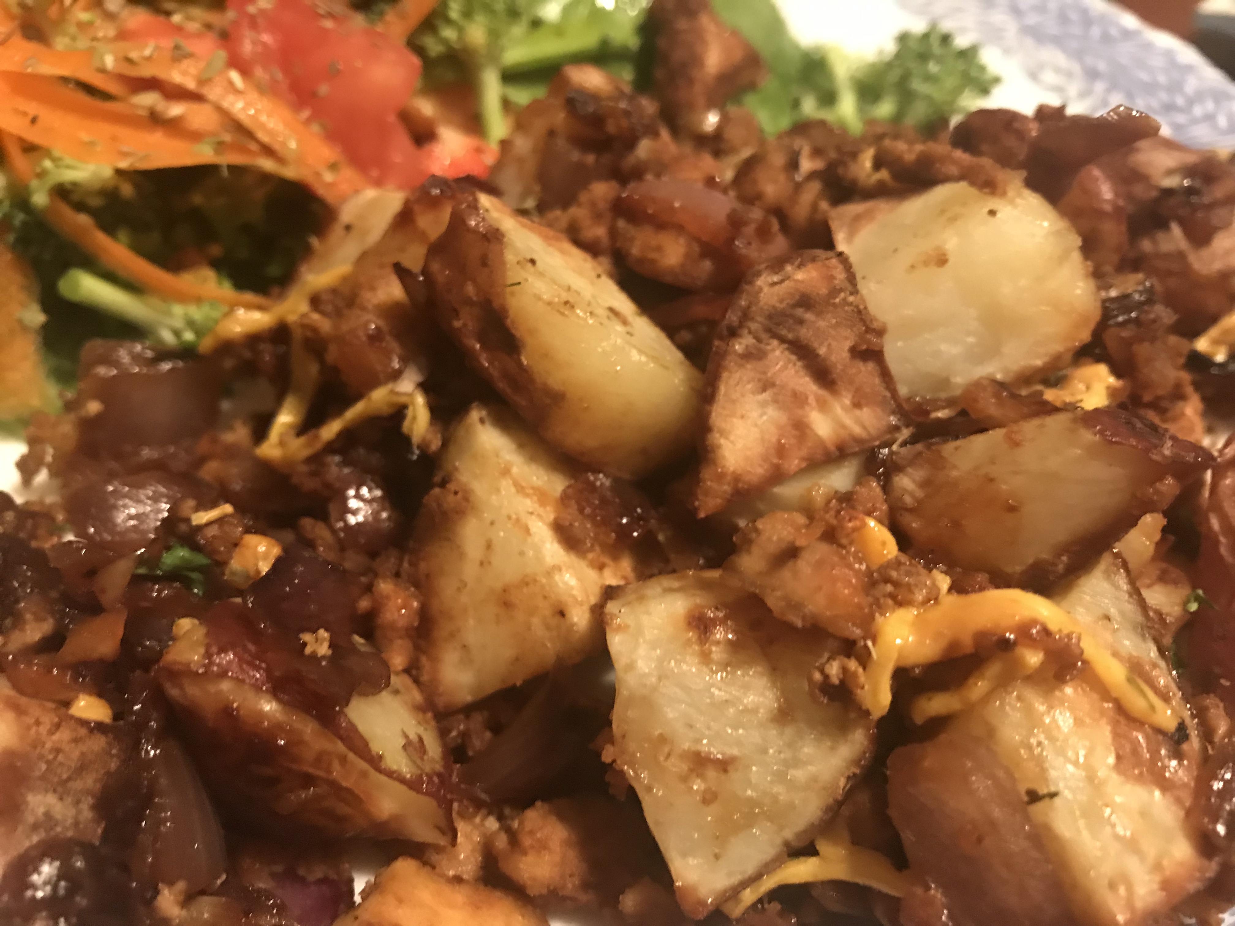 close up of diced potatoes topped with onions and tofu bacon