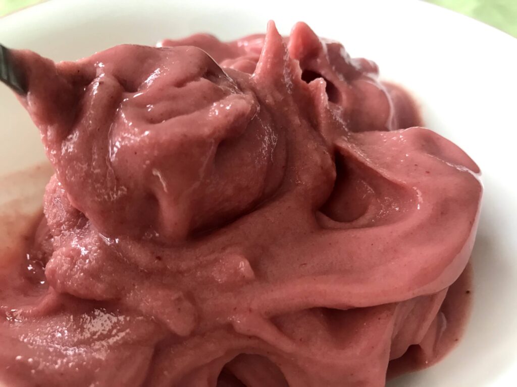 Bowl of Vegan Strawberry Ice Cream scooped in a spoon