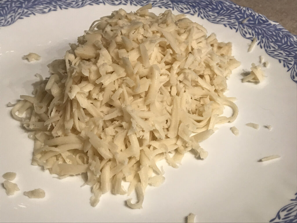 grated vegan mozzarella cheese on a plate